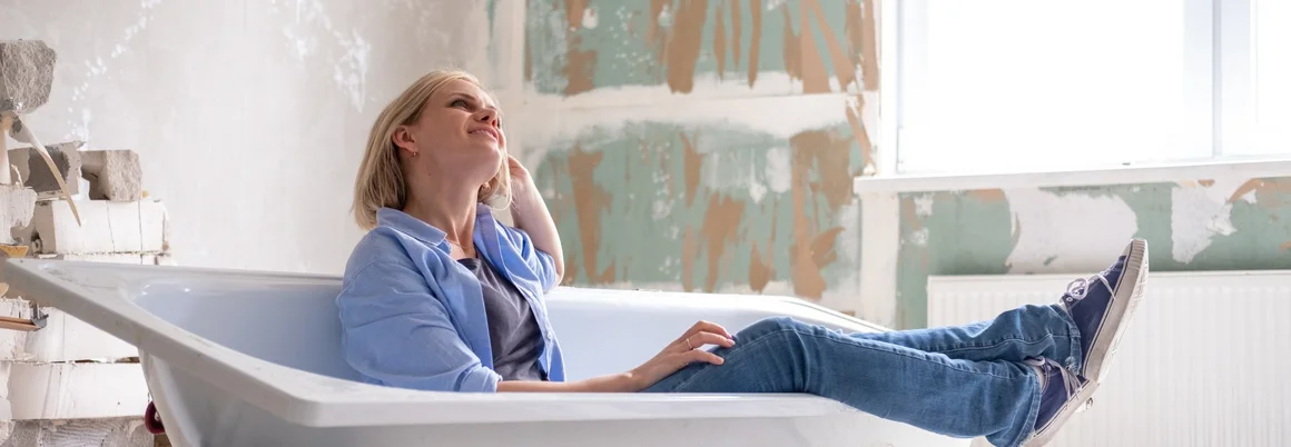 Person entspannt in Badewanne, die noch gar nicht montiert wurde